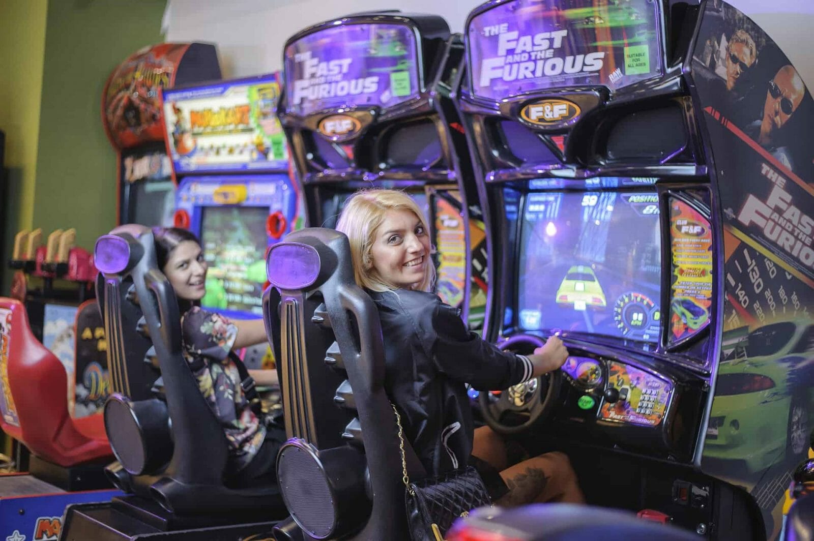 Image of 2 ladies playing Fast and The Furious Arcade Machine